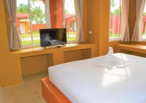 een slaapkamer met een bed, een tv en ramen bij World Cat Beach & Resort เวิลด์แคท บีช แอนด์ รีสอร์ท in Bang Saphan