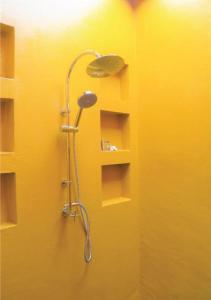 a shower in a bathroom with a yellow wall at World Cat Beach & Resort เวิลด์แคท บีช แอนด์ รีสอร์ท in Bang Saphan