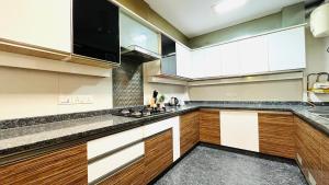 a kitchen with wooden cabinets and a large window at Olive Serviced Apartments - Defence Colony in New Delhi