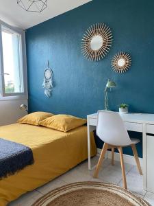 um quarto com uma cama, uma secretária e um espelho. em Charmant appartement quartier école d’agronomie em Montpellier