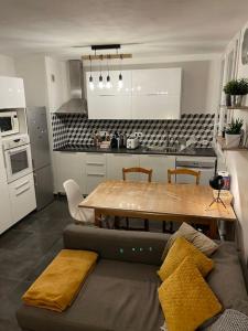 uma cozinha com um sofá e uma mesa numa cozinha em Charmant appartement quartier école d’agronomie em Montpellier