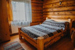 a bedroom with a bed in a log cabin at Cabana La Matei in Suceava