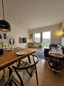 uma sala de estar com uma mesa e cadeiras num quarto em Lejlighed med altan og gratis parkering em Aalborg