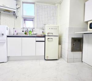 a kitchen with white cabinets and a refrigerator at k histay jongan in Seoul