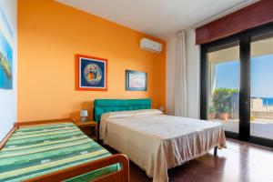 sypialnia z 2 łóżkami i pomarańczową ścianą w obiekcie Casa vacanze Calliope w mieście Tricase