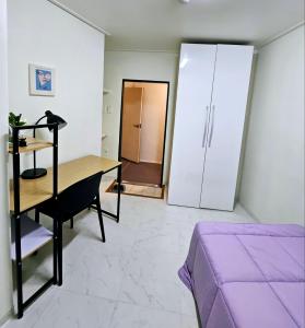 um quarto com uma secretária, uma cama e um frigorífico em k histay jongan em Seul
