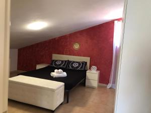 um quarto com uma cama preta e uma parede vermelha em Atena B&B APARTMENTS Imperial em San Silvestro