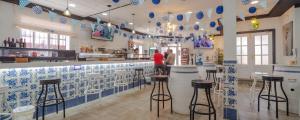 un restaurante con taburetes y baldosas azules y blancas en Hostal Valdepeñas by Bossh Hotels, en Valdepeñas