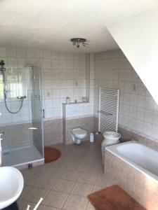y baño con bañera, aseo y lavamanos. en Room in Apartment - Haus Im Grunen House in the green, en Neuzelle
