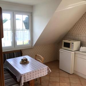 una pequeña cocina con mesa y microondas en Room in Apartment - Haus Im Grunen House in the green, en Neuzelle