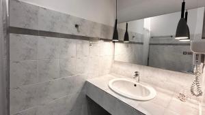 a white bathroom with a sink and a mirror at Chryssi Akti, Sure Hotel Collection in Batsi