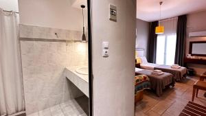 ein Bad mit einer Dusche und einem Waschbecken in einem Zimmer in der Unterkunft Chryssi Akti, Sure Hotel Collection in Batsi