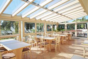 un restaurant vide avec des tables, des chaises et des fenêtres dans l'établissement Landgasthof Baumgartner, à Dingolfing