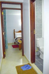 a bathroom with a toilet and a bed in a room at One bedroom Bnb in Thika7 in Thika
