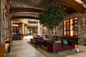 eine Lobby mit Sofas und einem Baum in einem Gebäude in der Unterkunft Archer Hotel Napa in Napa