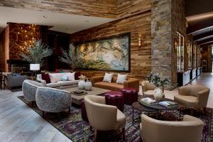 a lobby with couches and chairs and a painting on the wall at Archer Hotel Napa in Napa