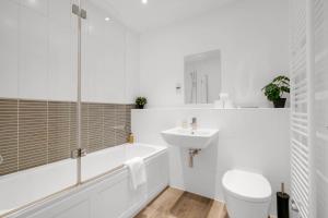 a white bathroom with a toilet and a sink at Foxherne 5BDR 3BA Serviced House with Parking - Slough By 360Stays in Slough