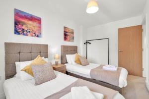 Duas camas num quarto com paredes brancas em Foxherne 5BDR 3BA Serviced House with Parking - Slough By 360Stays em Slough