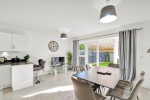 a kitchen and living room with a table and chairs at Foxherne 5BDR 3BA Serviced House with Parking - Slough By 360Stays in Slough