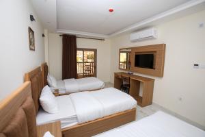 アカバにあるAl Sadrah View Hotel-فندق اطلالة السدرةのベッド2台とテレビが備わるホテルルームです。