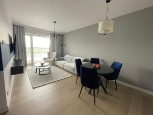 a living room with a table and a couch at Blue Dunes Apartament Polanki Aqua in Kołobrzeg