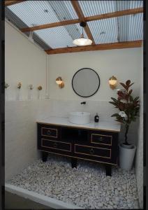 La salle de bains est pourvue d'un lavabo, d'un miroir et d'une plante en pot. dans l'établissement ภูเพียงพอ ณ เชียงราย, à Chiang Rai
