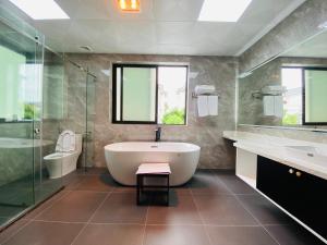 Un baño con bañera, ducha y lavabo. en Nice Villa Venuestay, en Ha Long 20 fotos más