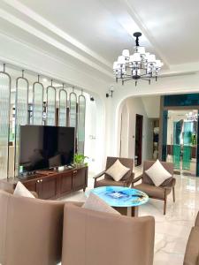 sala de estar con TV, sillas y mesa en Nice Villa Venuestay, en Ha Long