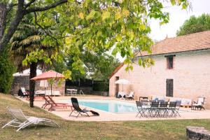 una piscina con sillas y mesas y una casa en LES CHARMES en Jugy