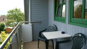 una mesa y sillas en el porche de una casa en Haus Kuhn en Carolinensiel