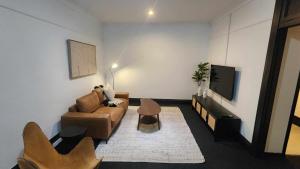 a living room with a couch and a tv at The Sherwood Hotel in Lismore