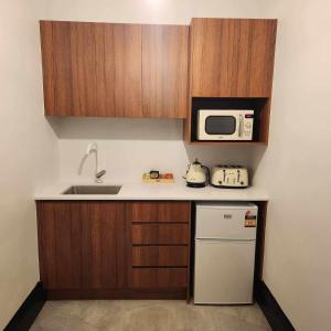 a small kitchen with a sink and a microwave at The Sherwood Hotel in Lismore