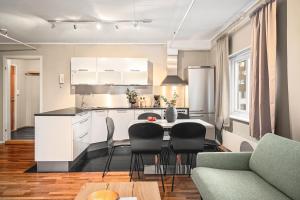 a kitchen and living room with a table and chairs at Enter Amalie Apartment Hotel in Tromsø