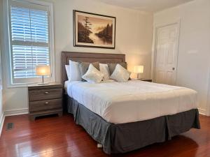 a bedroom with a large bed and two lamps at Spacious Detached House in Mississauga in Mississauga