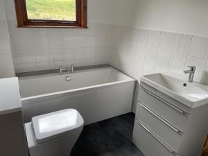 a bathroom with a tub and a toilet and a sink at Maol Ruadh in Roybridge