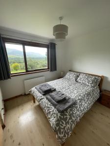 a bedroom with a bed and a large window at Maol Ruadh in Roybridge