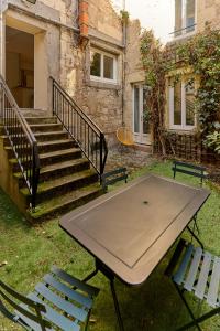 een picknicktafel en twee stoelen voor een gebouw bij "La Revenderie", appartement calme sur cour privative, hyper centre de Nevers by PRMO C0NCIERGERIE in Nevers