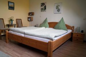 a wooden bed with green pillows in a room at Eifelferienhaus Thome - a34701 in Lissendorf