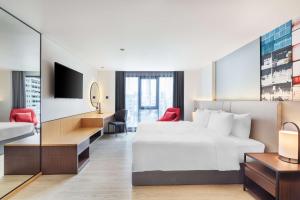 una camera d'albergo con letto, scrivania e TV di Best Western Click Sathorn 11 Bangkok a Bangkok