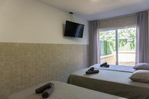 a bedroom with two beds and a tv on the wall at Apartamentos La Ruta in Calpe