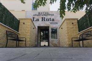a hotel entrance with two benches in front of a building at Apartamentos La Ruta in Calpe