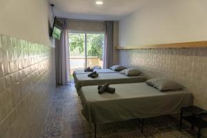 three beds in a room with a window at Apartamentos La Ruta in Calpe