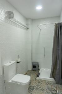 a white bathroom with a toilet and a shower at Apartamentos La Ruta in Calpe