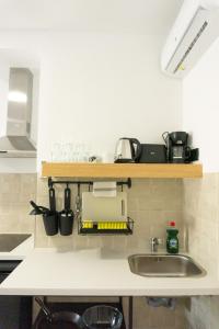 a kitchen counter with a sink and some pots and pans at Apartamentos La Ruta in Calpe