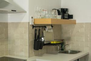 a kitchen counter with a sink and a shelf with utensils at Apartamentos La Ruta in Calpe