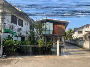 una casa con una valla delante de ella en Baan Jai Klang (บ้านใจกลาง) en Chiang Rai