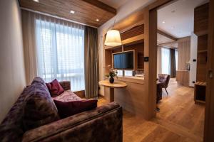 薩爾費爾德的住宿－Kulmberghaus Resort，带沙发、电视和桌子的客厅