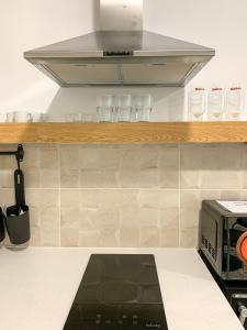 a kitchen with a microwave and glasses on a counter at Apartamentos La Ruta in Calpe
