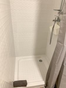 a bathroom with a shower with a white tiled tub at Apartamentos La Ruta in Calpe