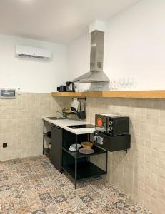 a kitchen with a counter with a stove top oven at Apartamentos La Ruta in Calpe